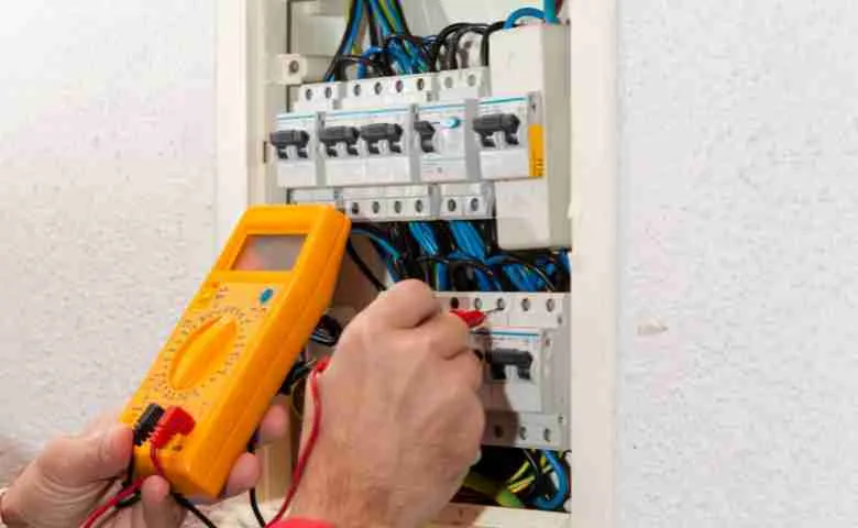 Electrician working on electrical panel, symbolizing the demand for electricians and the process of becoming one