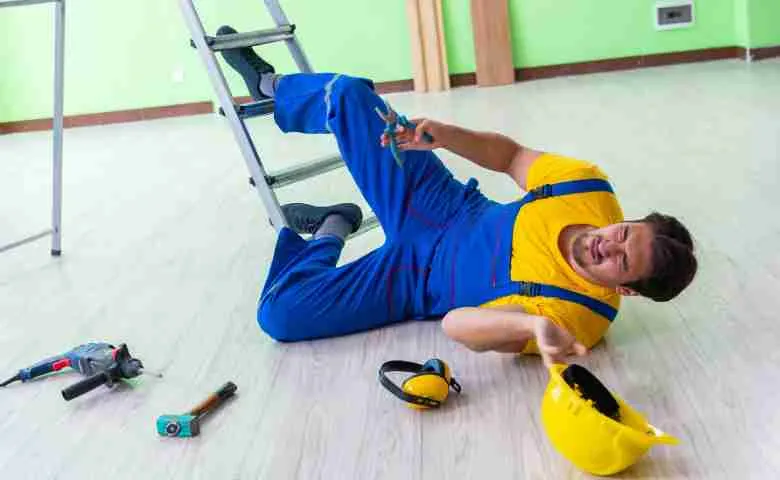 Construction worker receiving medical attention after slipping and falling on a construction site.