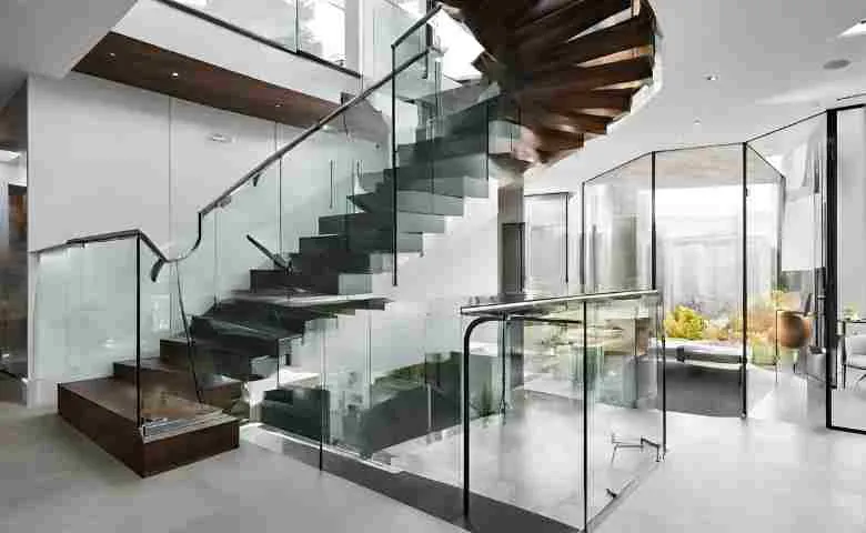 Modern staircase with glass railing overlooking a scenic view