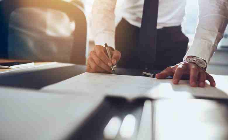 man signing documents