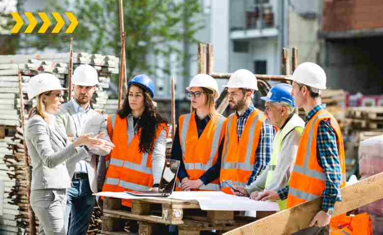 Construction workers wearing safety gear at a site, demonstrating hazard prevention measures.