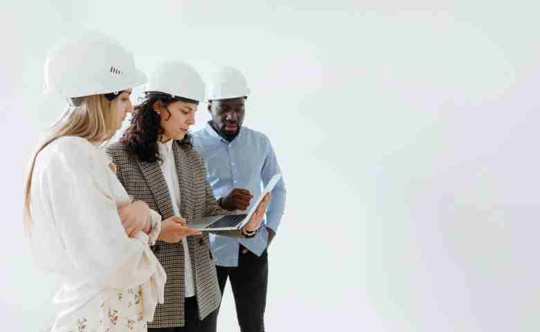 People Wearing Hard Hats discussing the business 