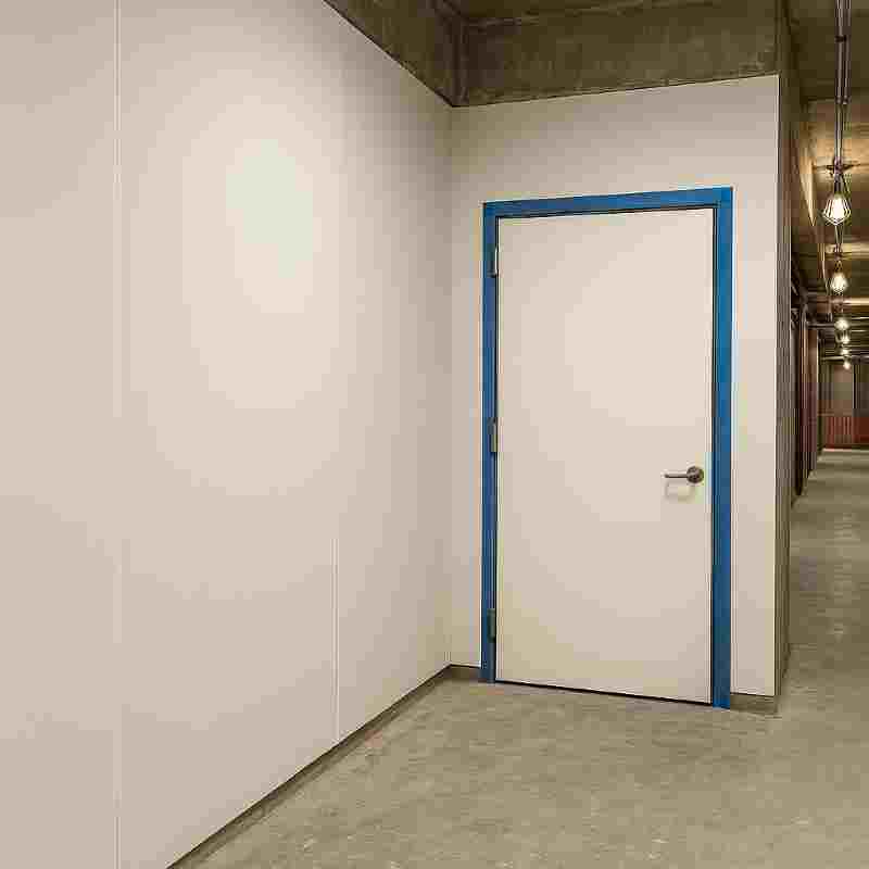 Temporary wall and door protection used in a construction corridor with exposed surfaces.