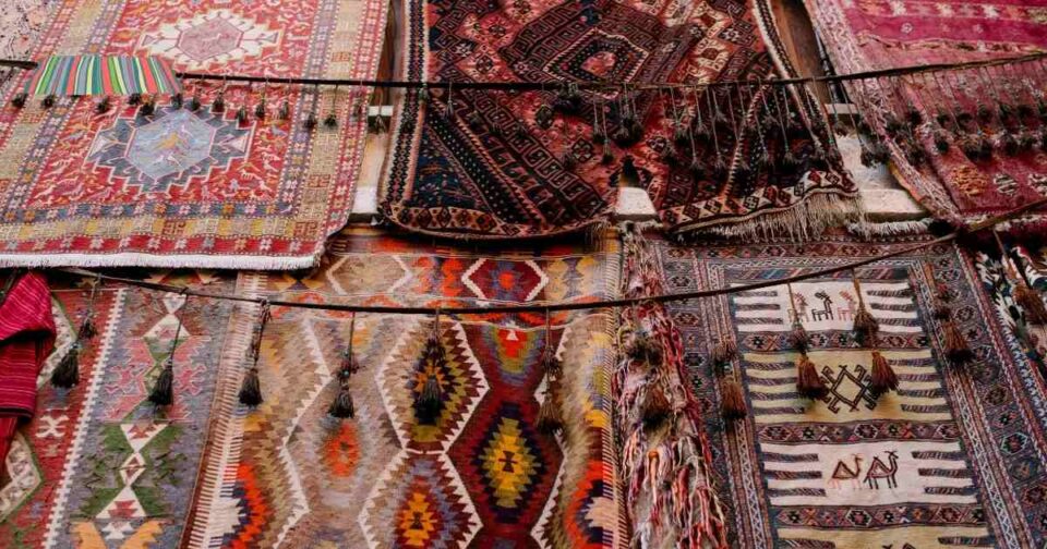 Layered area rugs with different textures and colors in a cozy living room