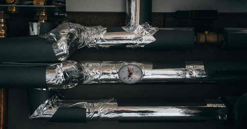 Pipes and equipment are installed on a wall.
