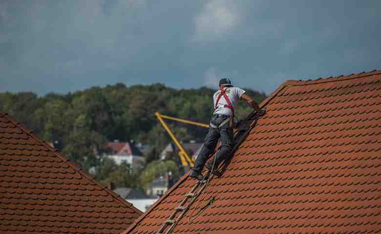 professional roof inspection showing inspector examining shingles and flashing
